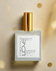 A bottle of Self Talk Dry Body Oil Mist with a white label and gold-colored cap.