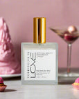 A clear spray bottle with a gold cap labeled 'LOVE' representing the dry body oil body mist product.