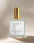 Champagne dry body oil mist bottle with gold cap on a white background