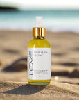 realx beach body oil sitting on the beach