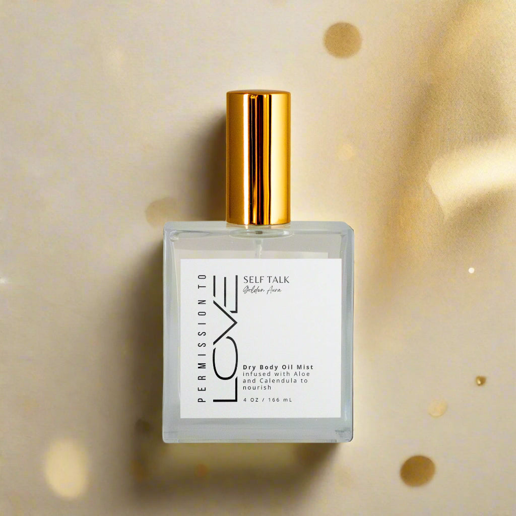 A bottle of Self Talk Dry Body Oil Mist with a white label and gold-colored cap.